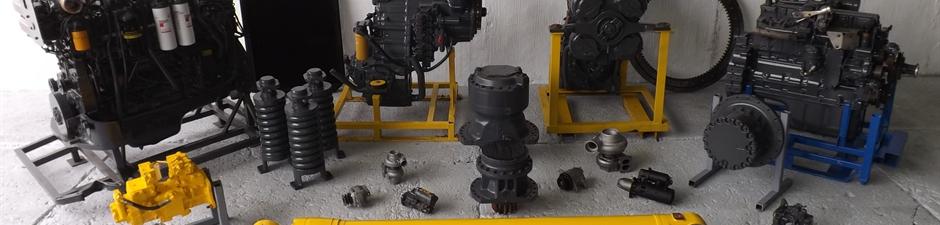 A variety of reconditioned Komatsu parts, including a recoil assembly for a Komatsu PC210-6, a transmission for a Komatsu WA470-5, a rebuilt SAA6D140E-3 engine, and a slew gear box for a Komatsu PC180-6
