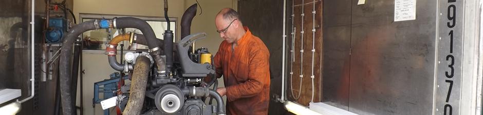 Engineer carrying out dynamometer testing of a Komatsu engine